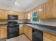 Bright kitchen featuring wooden cabinets and black appliances, perfect for cooking at 778 Leguin Mill Rd, Locust Grove, GA 30248