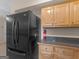 Kitchen appliance view, displaying a black refrigerator next to light wood cabinets at 778 Leguin Mill Rd, Locust Grove, GA 30248
