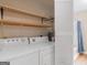 Laundry room featuring a washer, dryer, wood shelving and access to the bathroom at 778 Leguin Mill Rd, Locust Grove, GA 30248