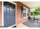 Covered front porch with stylish black and white rug and comfortable seating area at 1147 Dunivin Dr, Jonesboro, GA 30238