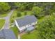 Overhead view of home featuring a gray deck, patio, mature trees, landscaping and a long driveway at 3100 Meadow Trl, Loganville, GA 30052