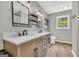 Beautiful bathroom features a double sink vanity with granite countertops and custom mirrors and shelving at 3100 Meadow Trl, Loganville, GA 30052