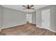 Bedroom featuring wood-look flooring, ceiling fan, and a view into an adjoining room at 3100 Meadow Trl, Loganville, GA 30052
