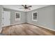 Bedroom featuring wood-look flooring, two windows, a ceiling fan and light fixture at 3100 Meadow Trl, Loganville, GA 30052