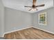 Bedroom featuring wood-look flooring, ceiling fan, and a window with natural light at 3100 Meadow Trl, Loganville, GA 30052