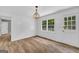 Bright dining room features wood-look floors, stylish lighting fixture, and white trim and paneled walls at 3100 Meadow Trl, Loganville, GA 30052