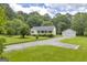 Scenic front view showcasing a cozy home with a large lawn and separate garage at 3100 Meadow Trl, Loganville, GA 30052