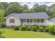 Charming single-story home with a welcoming front porch and lush green lawn and manicured landscaping at 3100 Meadow Trl, Loganville, GA 30052