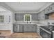 Updated kitchen with stainless steel appliances, granite countertops, and modern gray cabinetry at 3100 Meadow Trl, Loganville, GA 30052
