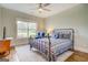 Bright bedroom with an iron bed frame, blue accents, hardwood floors, a ceiling fan and an area rug at 3076 East Lake Rd, Mcdonough, GA 30252