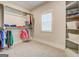 Bright walk-in closet with built-in shelving, hanging racks, and a window for natural light at 3076 East Lake Rd, Mcdonough, GA 30252