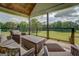 Relaxing covered porch with wicker furniture, offering picturesque views of the backyard at 3076 East Lake Rd, Mcdonough, GA 30252