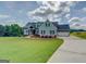 Charming home with beautiful lawn, blue siding, black shutters, and a long driveway at 3076 East Lake Rd, Mcdonough, GA 30252