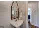 Charming powder room with a pedestal sink, decorative mirror, and shiplap wall for a touch of rustic elegance at 3076 East Lake Rd, Mcdonough, GA 30252