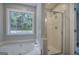 Bright bathroom featuring a relaxing soaking tub and separate glass shower with a natural light-filled window at 400 Kenny Ln, Temple, GA 30179