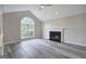 Inviting living room featuring a cozy fireplace, vaulted ceiling, and large arched window at 400 Kenny Ln, Temple, GA 30179