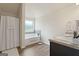 Bright bathroom featuring soaking tub with shower, dark wood cabinet, and neutral paint and decor at 1001 Hartwell Rd, Locust Grove, GA 30248