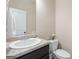 Clean half bathroom featuring a white sink, dark vanity, and neutral color palette at 1001 Hartwell Rd, Locust Grove, GA 30248