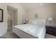 Bright bedroom features neutral walls, carpet, and a white bed with decorative pillows and matching nightstands at 1001 Hartwell Rd, Locust Grove, GA 30248