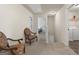 Carpeted hallway with chair seating area, offering access to laundry room and bedrooms, ideal for relaxation at 1001 Hartwell Rd, Locust Grove, GA 30248