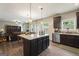 Modern kitchen featuring dark cabinets, granite countertops, stainless steel appliances, and open to the living room at 1001 Hartwell Rd, Locust Grove, GA 30248