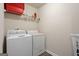 Utility room featuring washer, dryer, wire shelving, and laminate flooring at 1001 Hartwell Rd, Locust Grove, GA 30248