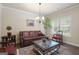 Cozy living room with a leather sofa, decorative coffee table, and natural light from a window at 1001 Hartwell Rd, Locust Grove, GA 30248