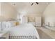Bright main bedroom featuring a large bed, ceiling fan, and white wicker furniture with matching decor at 1001 Hartwell Rd, Locust Grove, GA 30248