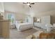 Spacious main bedroom featuring carpet flooring, white wicker furniture, and neutral walls and decor at 1001 Hartwell Rd, Locust Grove, GA 30248