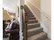 Carpeted staircase with wooden handrail and wrought iron spindles at 1001 Hartwell Rd, Locust Grove, GA 30248