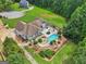 Expansive backyard featuring a pool, pergola, patio and firepit, surrounded by lush landscaping and green lawn at 1422 New Holland Cir, Mcdonough, GA 30252