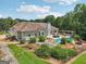 Well-maintained backyard featuring a pool, pergola, patio and firepit, surrounded by lush landscaping and a black fence at 1422 New Holland Cir, Mcdonough, GA 30252