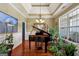 Elegant dining room with hardwood floors, tray ceiling, chandelier, grand piano, and natural light at 1422 New Holland Cir, Mcdonough, GA 30252