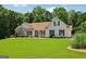Lovely home featuring green lawn, complemented by lush landscaping and traditional design elements at 1422 New Holland Cir, Mcdonough, GA 30252