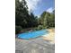 Inviting in-ground swimming pool featuring a unique design, surrounded by lush landscaping and a concrete patio at 1422 New Holland Cir, Mcdonough, GA 30252