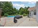Backyard pool area with spacious concrete patio surrounded by lush trees at 1422 New Holland Cir, Mcdonough, GA 30252