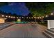 Inviting backyard with a spacious deck, pool, and outdoor dining area under a canopy of starry skies and warm string lights at 135 Cherokee Pl, Fayetteville, GA 30215