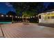 Spacious backyard featuring a large deck perfect for entertaining, with a pool and outdoor dining under festive string lights at 135 Cherokee Pl, Fayetteville, GA 30215