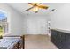 Carpeted bedroom with two closets, a ceiling fan, and natural light from a large window at 135 Cherokee Pl, Fayetteville, GA 30215