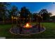 Cozy fire pit area with ambient string lights, comfortable seating, and a peaceful setting for evening relaxation at 135 Cherokee Pl, Fayetteville, GA 30215