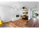 Living room with hardwood floors, white brick fireplace, and brick accent wall at 135 Cherokee Pl, Fayetteville, GA 30215