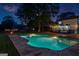 A serene pool area at twilight, complete with a shimmering pool, a cozy fire pit, and ambient string lighting at 135 Cherokee Pl, Fayetteville, GA 30215