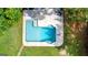 Aerial view of a sparkling pool surrounded by a concrete deck and lush greenery, perfect for summer relaxation at 135 Cherokee Pl, Fayetteville, GA 30215