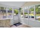 Bright sunroom with brick floors, white trim, many windows, and views of the pool at 135 Cherokee Pl, Fayetteville, GA 30215
