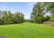 Sprawling backyard featuring lush greenery and mature trees under a clear blue sky at 4002 Joshua Ln, Douglasville, GA 30135