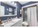 Bright bathroom featuring a marble countertop vanity and shower with vertical striped curtain at 4002 Joshua Ln, Douglasville, GA 30135