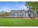 Exterior of a blue home showcasing a spacious deck and manicured lawn surrounded by lush greenery at 4002 Joshua Ln, Douglasville, GA 30135