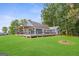 Charming blue house featuring a large deck, a pergola, and a well-manicured green lawn surrounded by mature trees at 4002 Joshua Ln, Douglasville, GA 30135