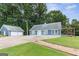 Attractive home exterior with a two-car garage, deck, and lush green surroundings at 4002 Joshua Ln, Douglasville, GA 30135