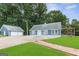 Charming home exterior with a two-car garage, deck, and lush green surroundings at 4002 Joshua Ln, Douglasville, GA 30135